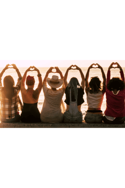 Group of women in sunset at beach after their first day of surfing retreat